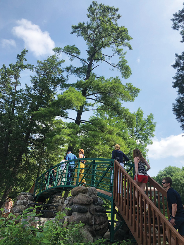 People cross a bridge on the "Boathouses of Lake Minnetonka" tour.