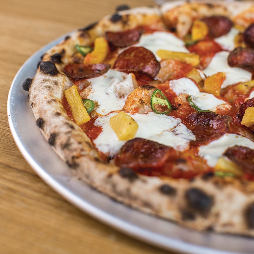 pineapple fra diavolo pizza topped with calabrese (sprouting brocolli), serrano peppers and mozzarella