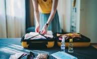 A woman packs her suitcase before a trip.