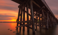 A long exposure photograph shows a summer sunset on Lake Minnetonka