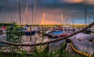 Rainbows paint the sky over boats on Lake Minnetonka.