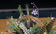 May basket with flowers and feathers