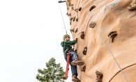 A boy climbs a rock wall at the St. David's Center Get Out and Grow fall festival.