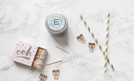 Matches, an Excelsior Candle Co. candle and two gold and white straws.