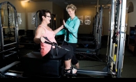  Shawn Marquis, right, assists Jennifer Barada on a Pilates machine. 