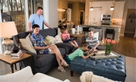  The Musgjerd family in their living room: Scott and Melissa with Lucas (in green), Daniel (in stripes), Jake (in coral) and Tilley the dog.