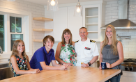 A military family poses for a photo in their kitchen.