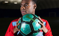 Orono grad Guy Mohs, originally from Haiti, holds a soccer ball.