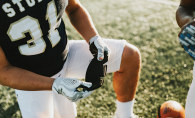 A football player holds a NoSweat liner for their helnet.