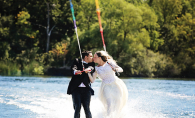 A Minnetonka couple water skis in their wedding attire for their unique save-the-date photo.