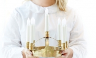 A performer in the American Swedish Institute's St. Lucia concert holds a candle crown