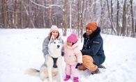 Family in the snow with their dog.