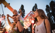 A man and woman with their son at a destination music festival.