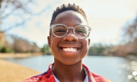 A child smiles, wearing their new glasses after a Vistagraph reading comprehension test.