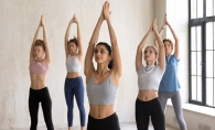 A group of women do the yoga pose Tadasana, or mountain pose, to center their spirits.