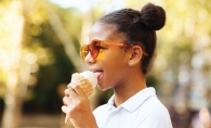 A girl eats an ice cream cone. 
