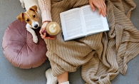 Cozy reading time Woman reading while snuggled with dog