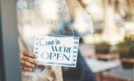 A shop celebrating Small Business Saturday hangs a "Come in we're open" sign in the window.