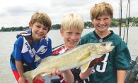 Three boys hold a walleye they caught from Lake Minnetonka, thanks to the help of the Westonka Walleye Program.
