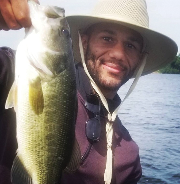Former Minnesota Vikings player Marcus Sherels holds up a fish.