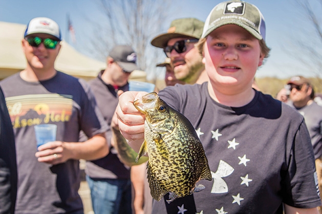 A boy holds his catch at the 51st Annual Minnesota Bound Crappie Contest
