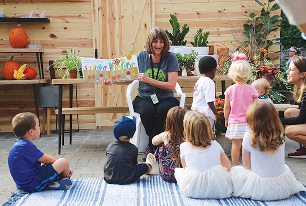 A woman reads to children at Tonkadale Greenhouse's Third Thursdays event.