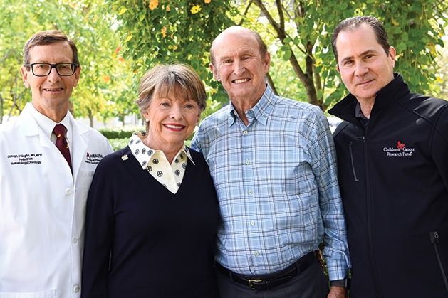 Diana and Norm Hageboeck,  center, pose with Joe Neglia, M.D.,  left, and Children’s Cancer Research  Fund CEO Daniel Gumnit, right.