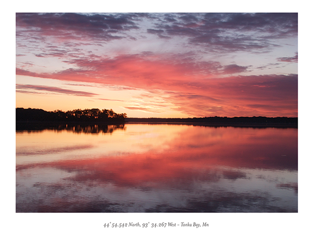 The sun sets on the horizon over a lake.