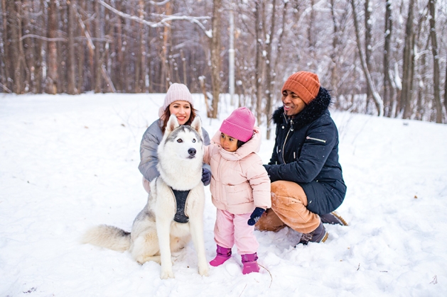 Family in the snow with their dog.