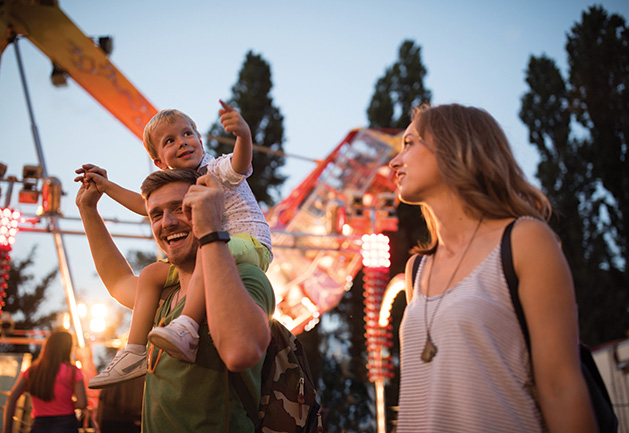 A man and woman with their son at a destination music festival.