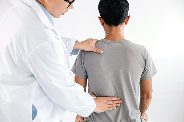 A chiropractor works on a patient's back at The Brost Clinic.