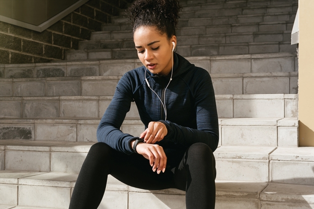 Young female runner checks her pulse