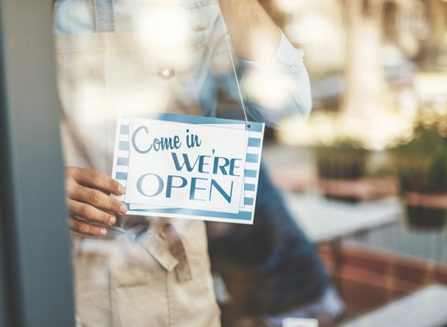 A shop celebrating Small Business Saturday hangs a "Come in we're open" sign in the window.