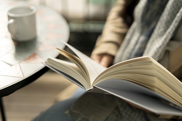 A person reads a book at a cafe.