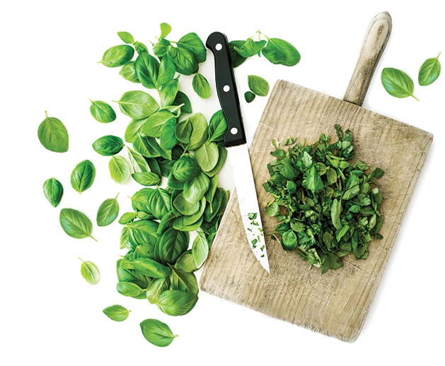 Leaves sit sliced on a cutting board in preparation for dinner party.