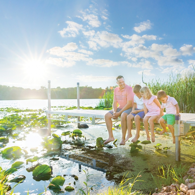 Dad with his three kids on the dock at Lake Tamarack.