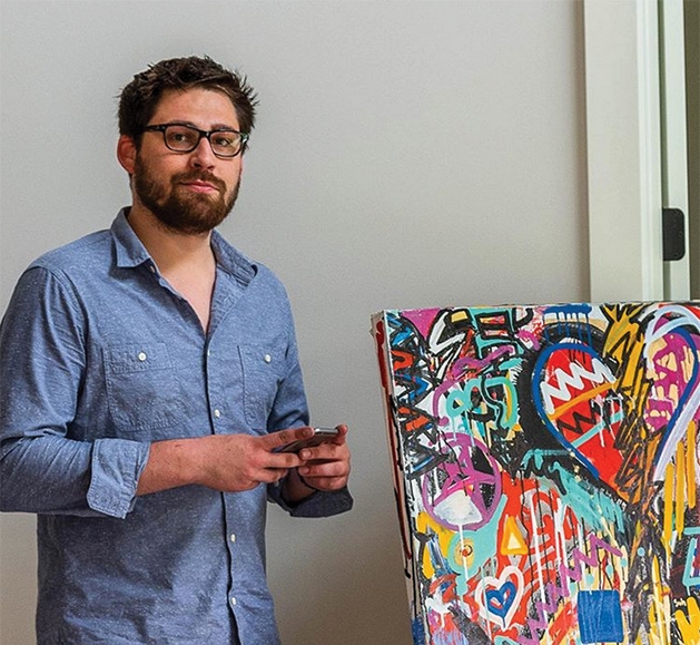 Painter Justin Hammer stands by one of his paintings.