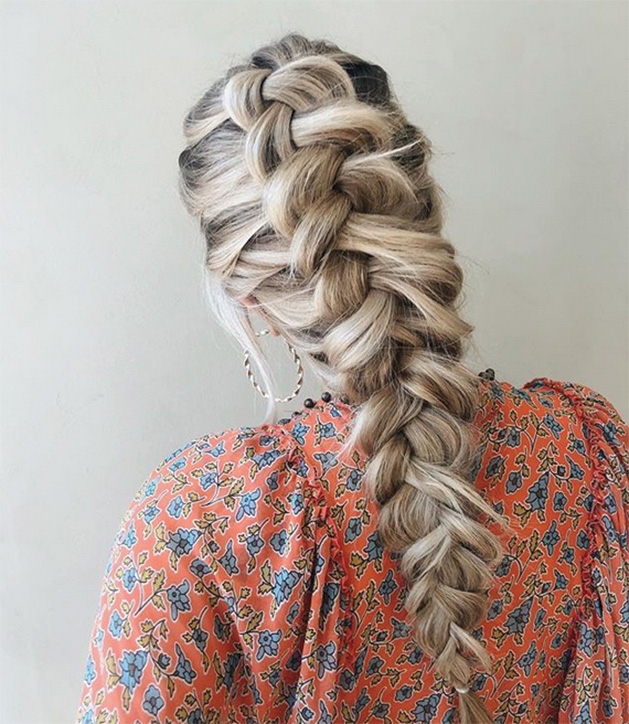 A woman models her braids done by Sil'Vie Hair Studio