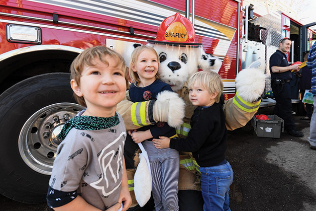 A firefighter dalmatian mascot poses with kids at the Our Savior Lutheran Church Easter Egg Hunt.