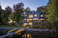 Brightly lit lakeside house at dusk