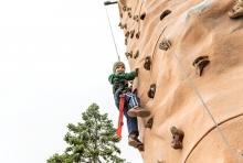 A boy climbs a rock wall at the St. David's Center Get Out and Grow fall festival.