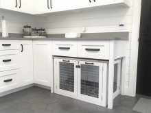 A dog bed built into the underside of kitchen cabinets.