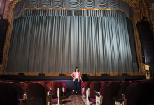 Ari Koehnen Sweeny, director of education for the Hennepin Theatre Trust, stands in front of a stage.