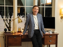 Paul Douglas leans on a desk in his Lake Minnetonka home.