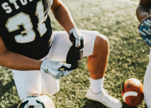 A football player holds a NoSweat liner for their helnet.