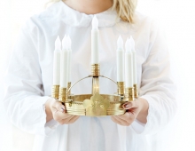 A performer in the American Swedish Institute's St. Lucia concert holds a candle crown