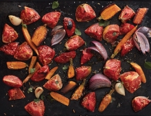 Roasted tomatoes, carrots and onions in a sheet pan.