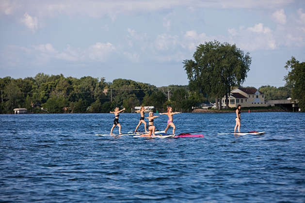 Women paddleboarding during a bachelorette party on Lake Minnetonka