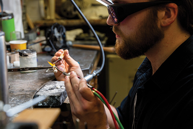 A jewelry designer inspects a gem at Veberod Gem Gallery